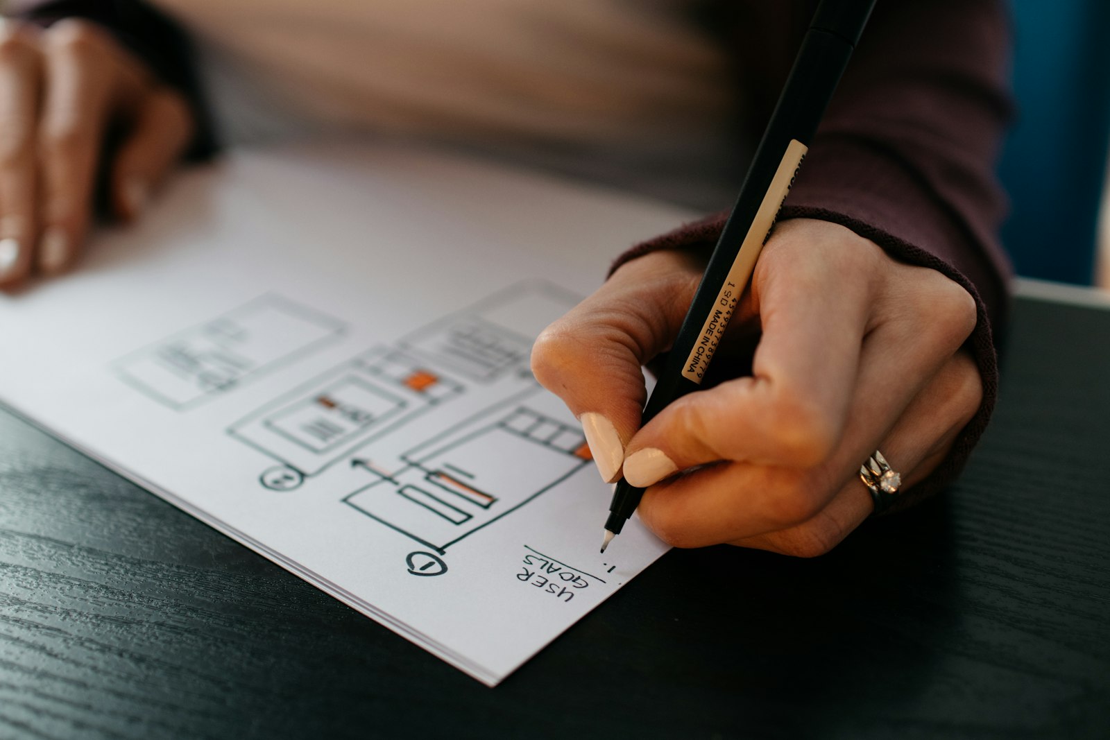 A designer sketching interface wireframes by hand